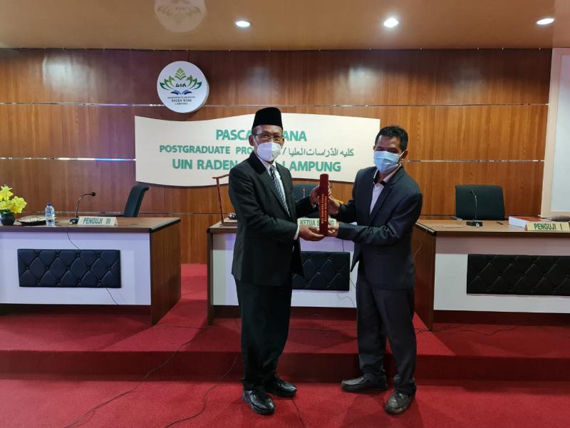 Penyerahan Piagam oleh Ketua Sidang kepada Dr. Rada, M.Pd.I
